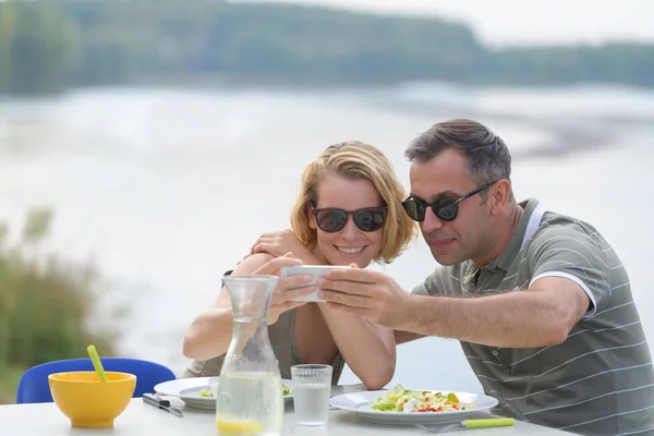 Gelukkige paar nemen selfie in openlucht restaurant — Stockfoto