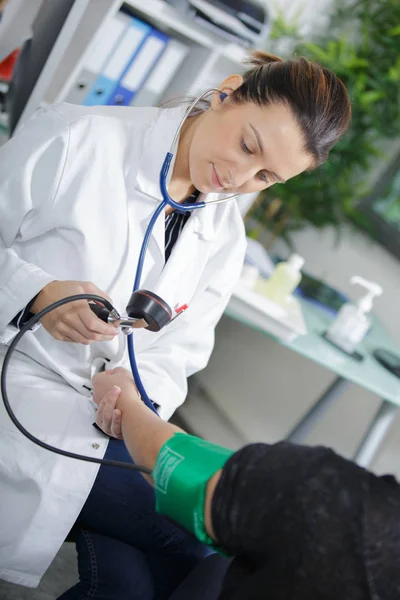 Female doctor is measuring the blood pressure — Stock Photo, Image