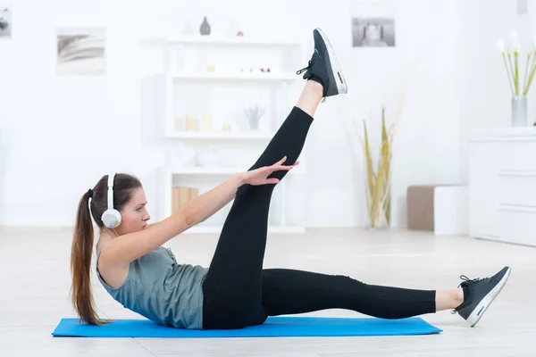 Slender athletic girl doing yoga exercises indoor — Stock Photo, Image