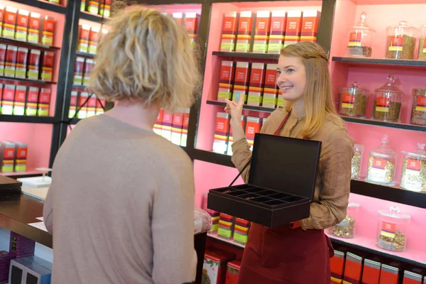 Positieve vrouwelijke kopers kiezen thee op de schappen van de supermarkt — Stockfoto