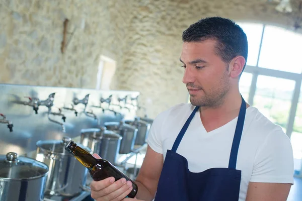 Brewery worker holding bottle — Stock Photo, Image