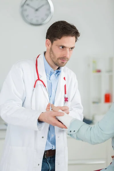 Retrato de un médico bastante masculino dando primeros auxilios al paciente —  Fotos de Stock