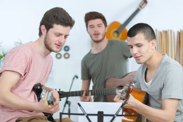 Three young men with the guitars — Stock Photo, Image