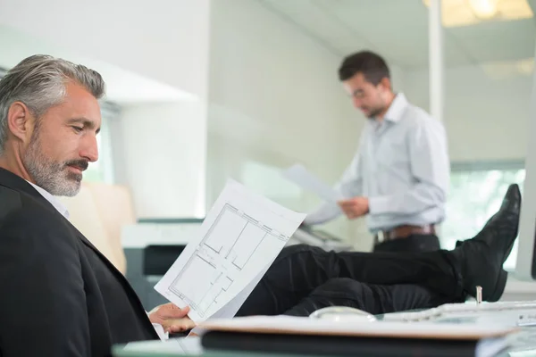 Hombre de negocios senior con los pies en el escritorio — Foto de Stock