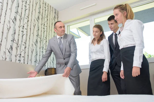 Mann mit Hotelpersonal hält Bettdecke in der Hand — Stockfoto