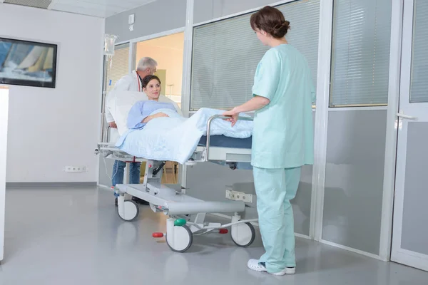 Läkare som transporterar kvinnlig patient på sjukhus — Stockfoto
