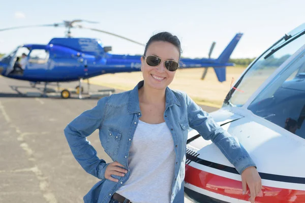 Ganska pilot kvinna på helikopter bakgrund — Stockfoto