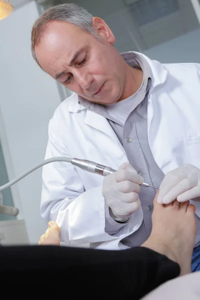 Podiatrist working on patient'sbig toe — Stock Photo, Image