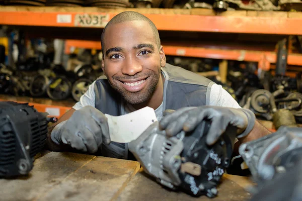 Man selecting second hand car part from shelf