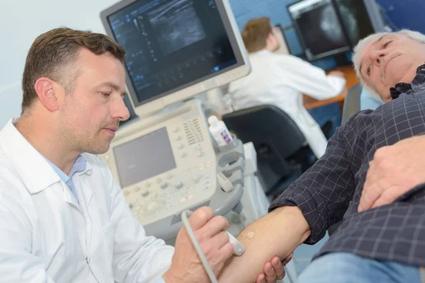 Internista examinando paciente idoso com ultrassom — Fotografia de Stock