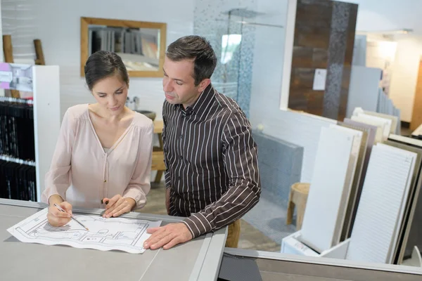 Architectes masculins et féminins vérifiant les plans dans leur bureau — Photo