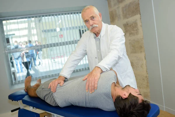 Chiropractor turning patient and chiropractor — Stock Photo, Image