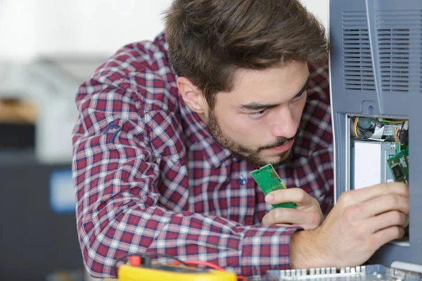 Giovane che fissa le parti del pc all'ufficio — Foto Stock