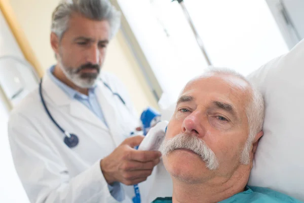 Arzt überprüft mit medizinischem Gerät das Ohr des Patienten — Stockfoto