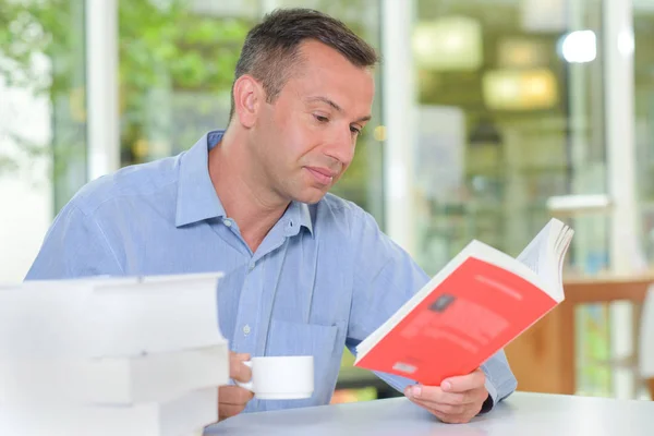 Becher mit Getränken während des Lesens — Stockfoto