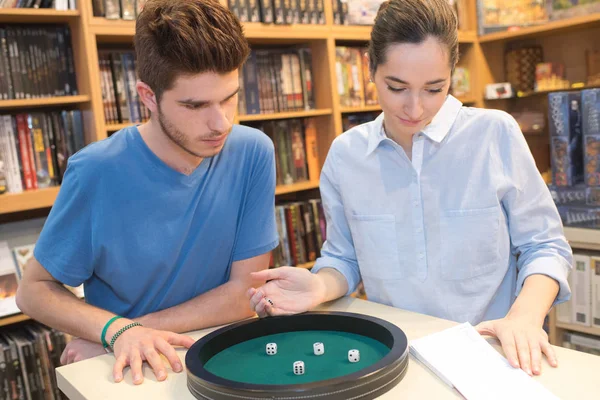 Adolescente chica y chico jugando dados — Foto de Stock