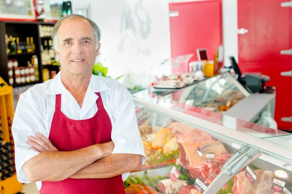 Butcher stood in shop with arms crossed — Stock Photo, Image