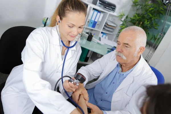 Médico masculino explicando aprendiz cómo mensurar la presión —  Fotos de Stock