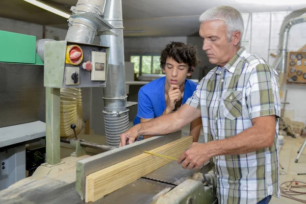 Tischler mit Lehrling, Holz messen — Stockfoto