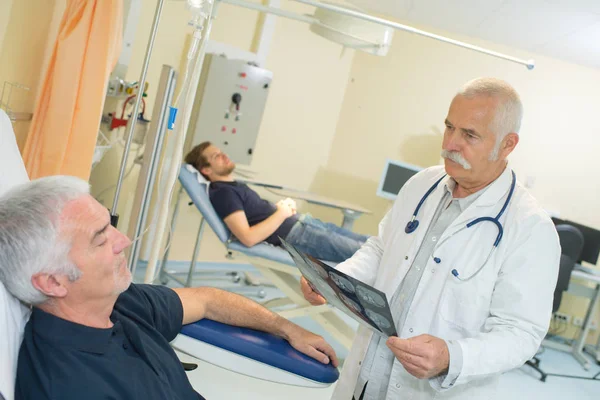 Médico e paciente olhando para o raio-x — Fotografia de Stock