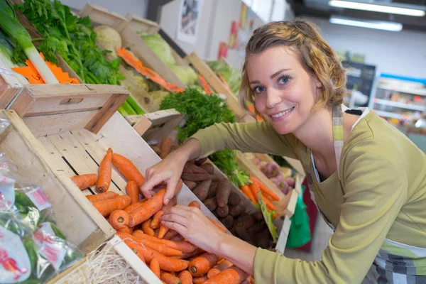 Vendedor feminino sorridente no mercado de legumes — Fotografia de Stock