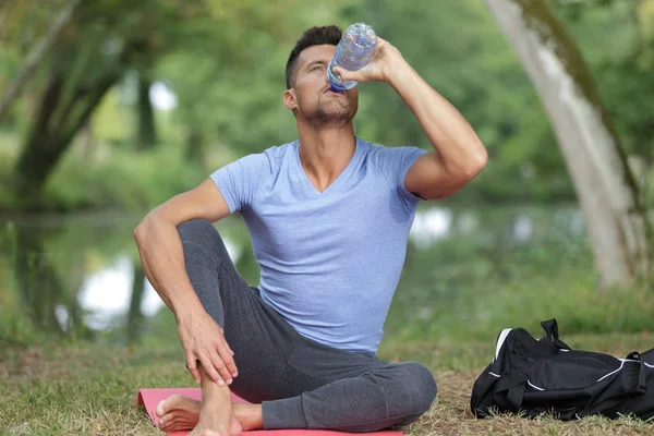 Человек пьет воду после тренировки — стоковое фото