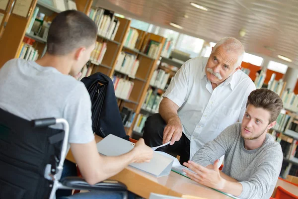 Adolescent handicapé faisant ses devoirs avec le professeur — Photo