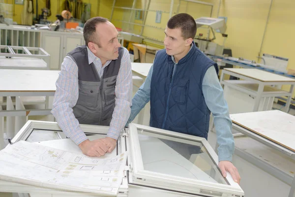 Aprendiz aprendiendo de un trabajador senior en la fábrica de ventanas — Foto de Stock