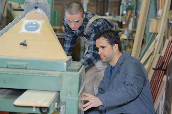 Formation de menuisier apprenti homme à utiliser une scie mécanisée — Photo