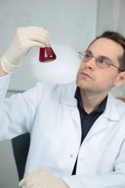 Hombre sosteniendo Erlenmeyer frasco — Foto de Stock