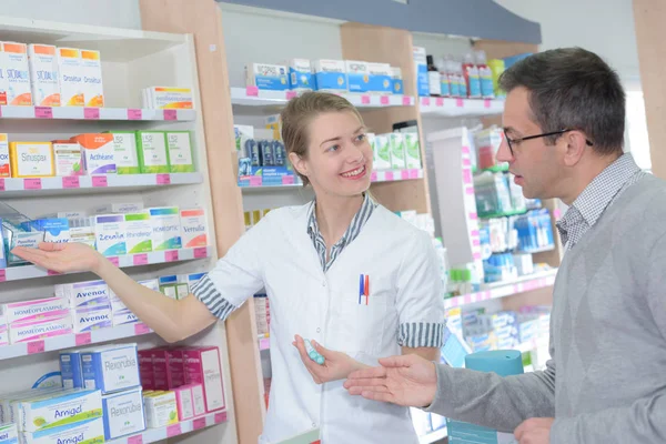 Farmacéutico que asiste a un cliente en farmacia — Foto de Stock