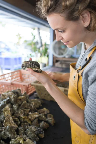 Une agricultrice d'huîtres nettoie ce qu'elle a produit — Photo