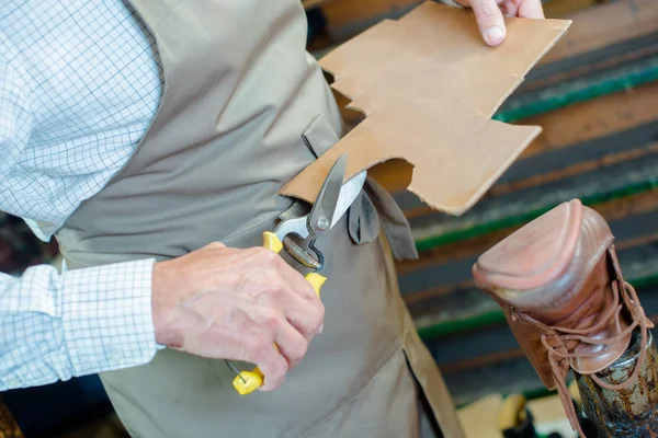 Cobbler cutting cardboard and body — Stock Photo, Image