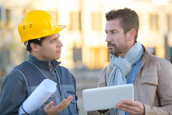 Ingeniero con sombrero duro usando tableta hablando con supervisor — Foto de Stock