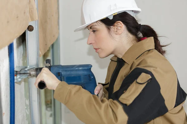 Eine Bauarbeiterin beim Bohren — Stockfoto