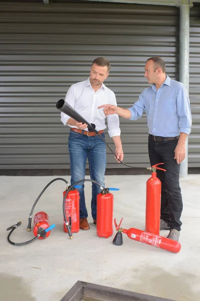 Dos hombres examinando extintores —  Fotos de Stock