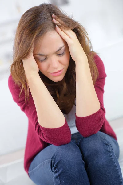 Młoda kobieta z twardego ból głowy, trzymając się za ręce na głowę — Zdjęcie stockowe