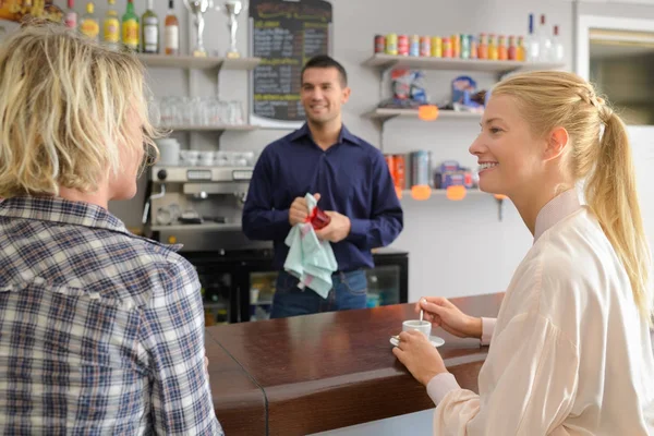 Kafede iki kadın üzerinden sipariş almayı bekleyen garson — Stok fotoğraf