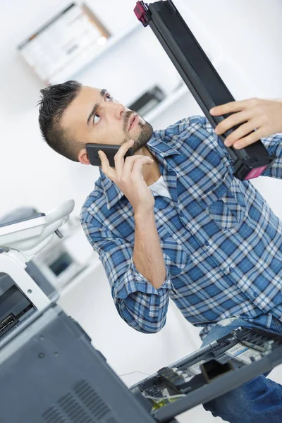 Hombre inspeccionando una pieza de impresora —  Fotos de Stock