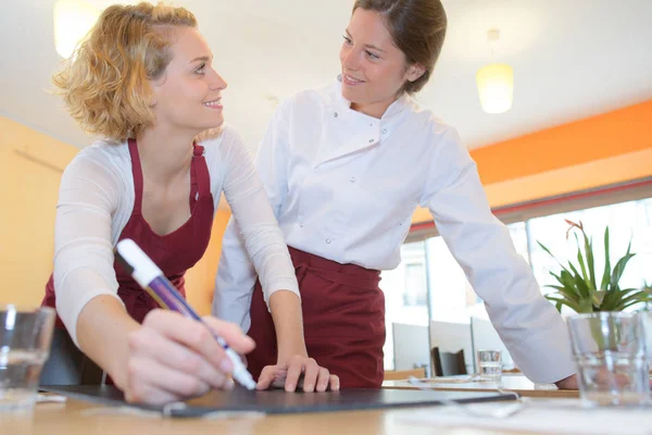 Servitris och koka talar i restaurangen — Stockfoto