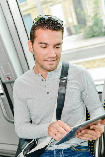 Homme utilisant sa tablette à l'intérieur d'un transport public — Photo