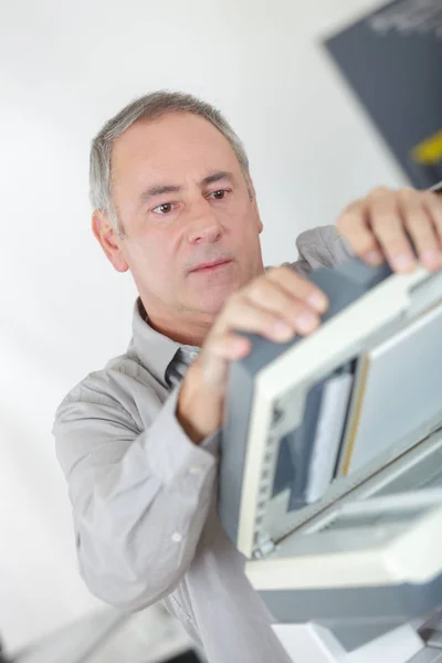 Geschäftsmann hält Tintenpatrone zum Einstecken in Drucker — Stockfoto