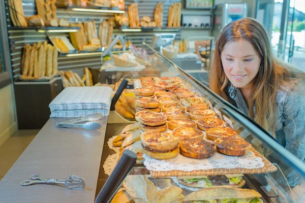 stock image Young woman buying some quiche