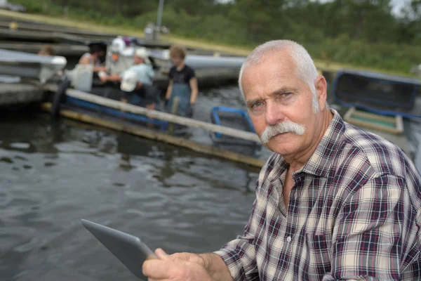Senior manager man som arbetar i en fiskodling — Stockfoto