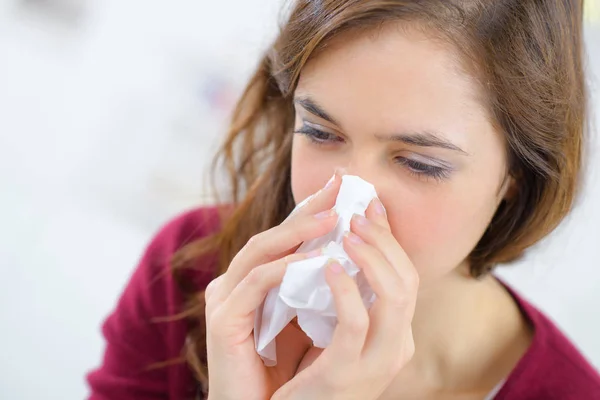 Close-up of young woman sneezing at home — Stock Photo, Image