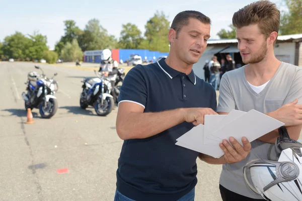 Rij instructeur gesprekken aan student voordat motor licentie testen — Stockfoto