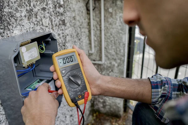 Elektrikçi bir voltmetre aygıtı kullanma — Stok fotoğraf