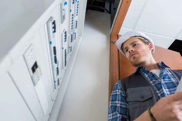 Young electrician working on electric panel — Stock Photo, Image
