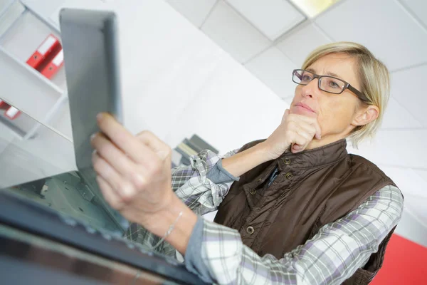 Contemplatieve vrouw kijken naar Tablet PC — Stockfoto
