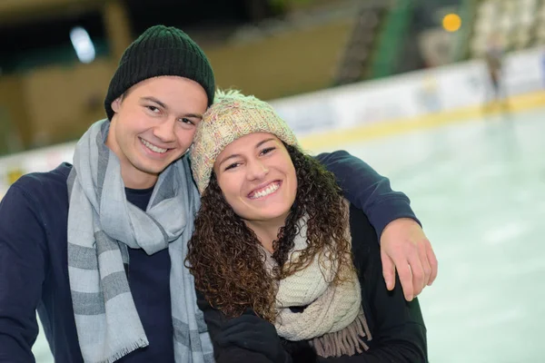 Retrato de belo casal jovem patinação no gelo na pista — Fotografia de Stock